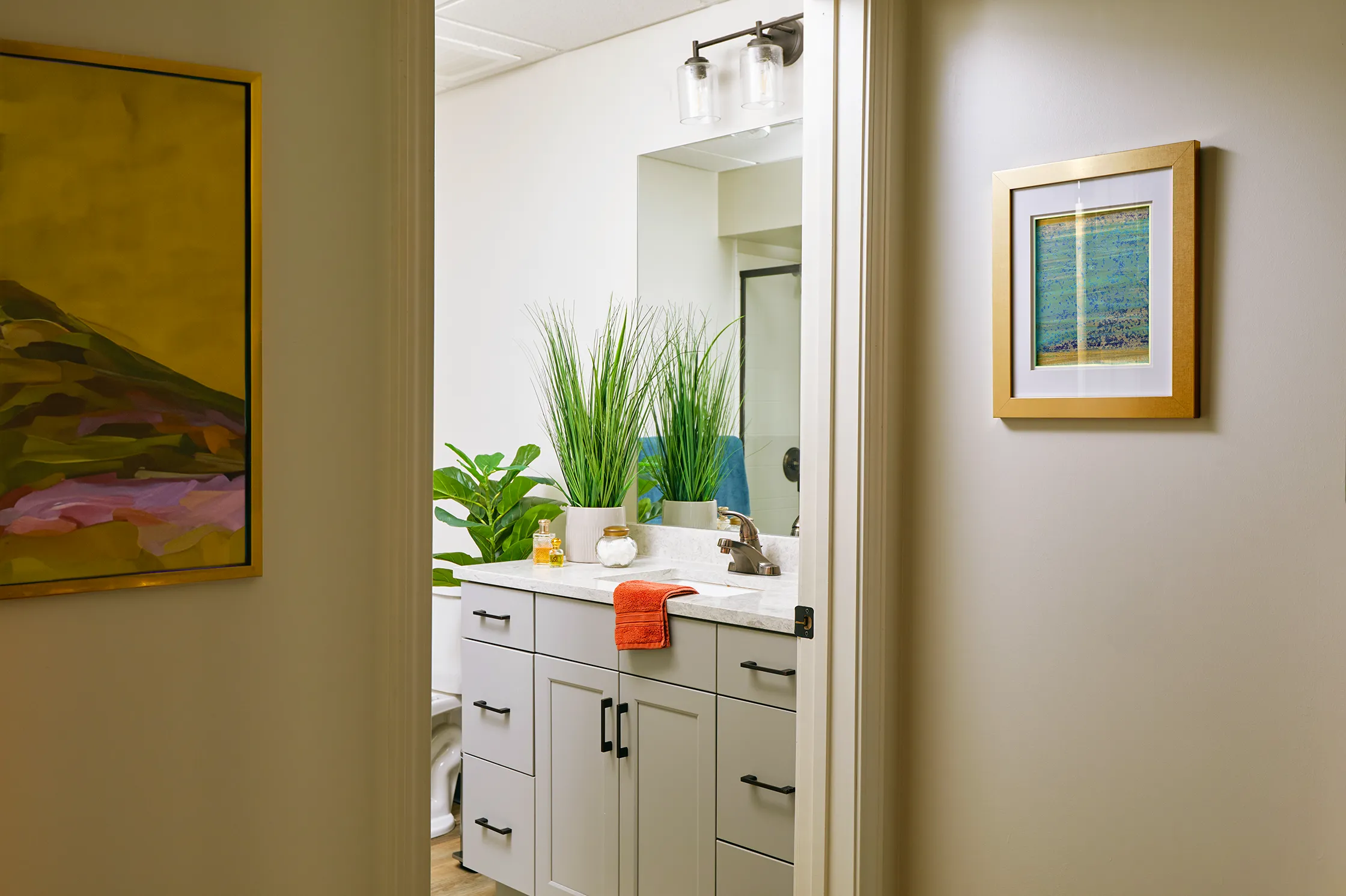 Cozy bathroom at The Tribute Knoxville, TN, with modern fixtures, elegant lighting, and a sleek vanity for a relaxing ambiance